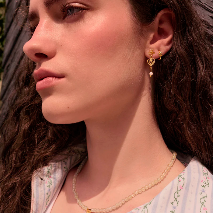 Model med Maanesten Izabel øreringe i forgyldt sølv med ferskvandsperle