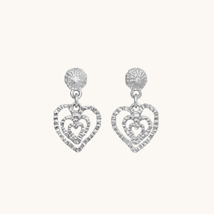 Maanesten Sada øreringe i genanvendt sterlingsølv (925) med hvide zirkonia og åbne hjerteformer i lagdelt design.