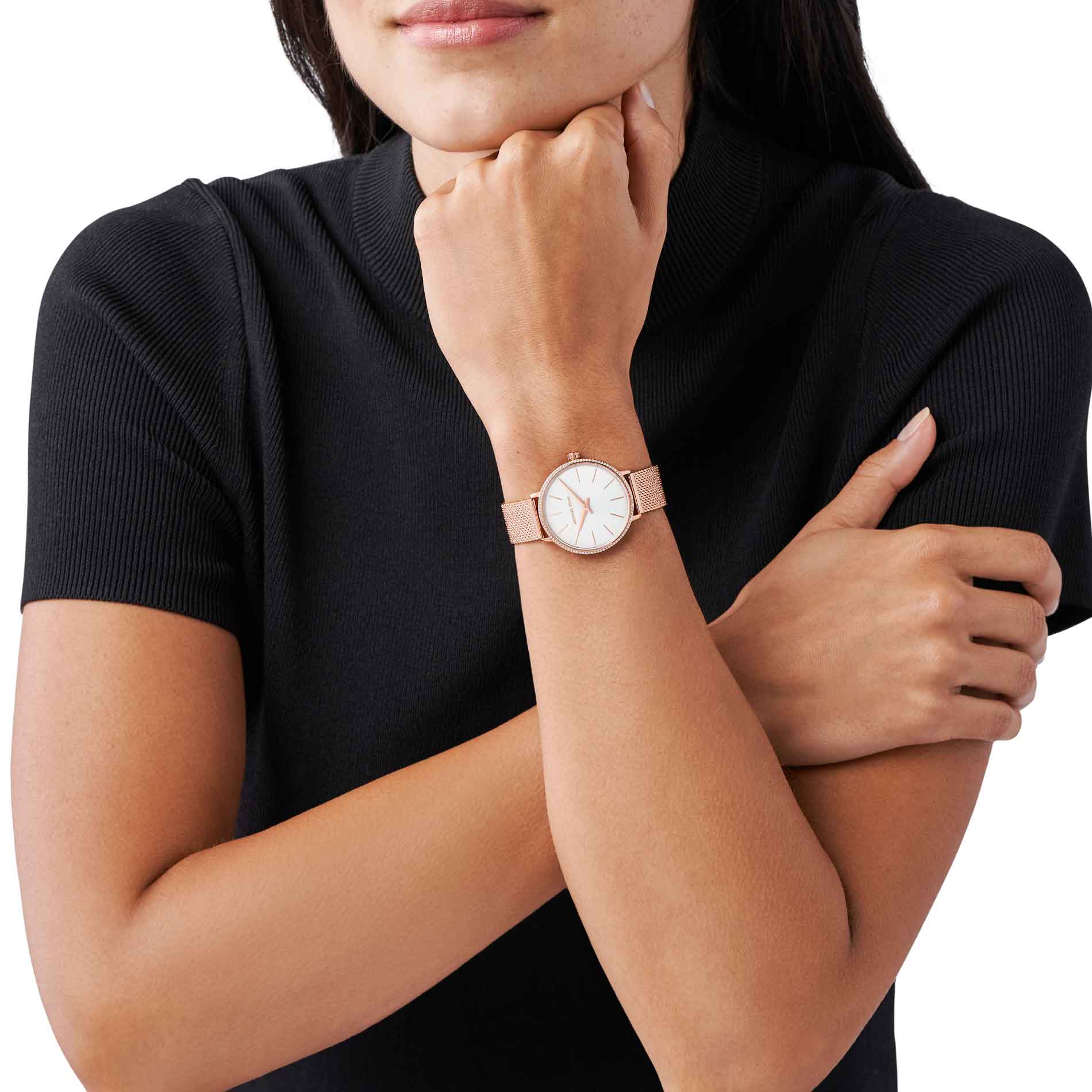 Rosafarvet Michael Kors Pyper MK4588 dameur med hvide i kransen og hvid urskive. Uret har mesh-lænke. Uret ses på håndledet af en kvinde iført en sort T-shirt.