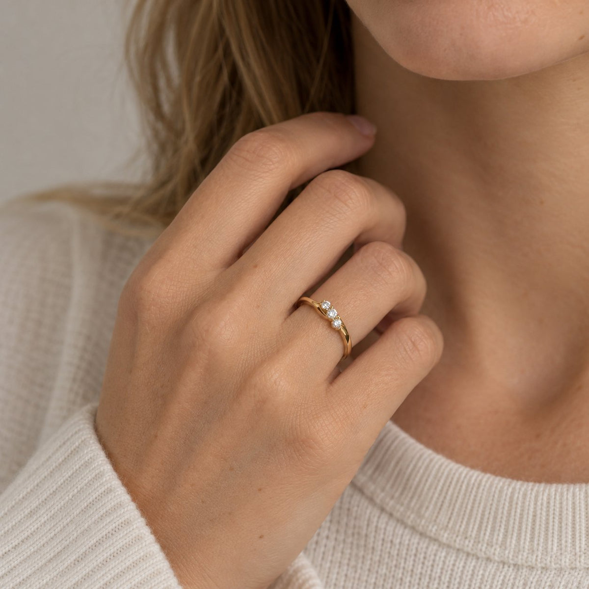 Kvinde i lys strik bærer Milan ring i guld med diamanter