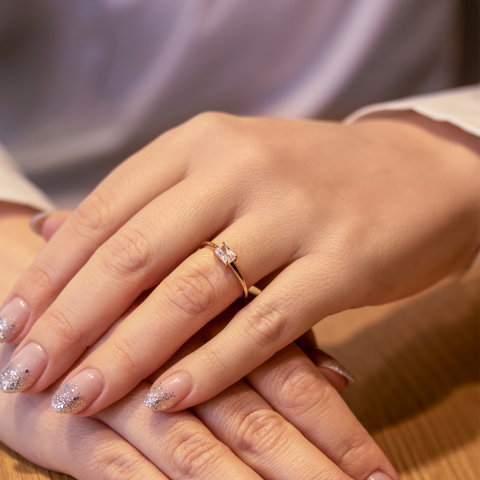 Elegant forgyldt ring med funklende sten båret på hånd