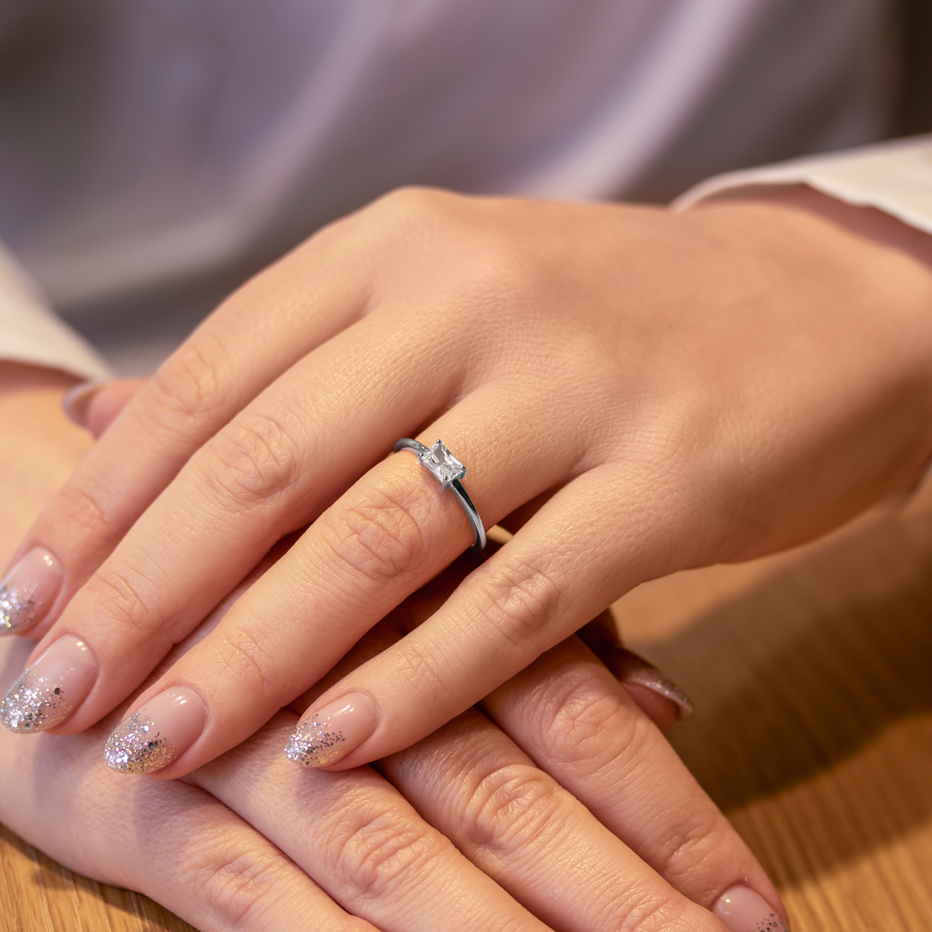 Elegant sølvfarvet ring med funklende sten båret på hånd