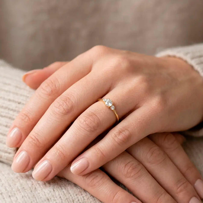 Nina ring i forgyldt sølv med tre hvide zirkonia båret på finger