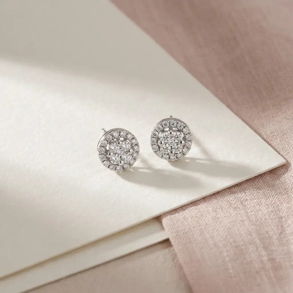 Nora ørestikker i hvidguld med 0,23 carat diamanter på lyst papir og rosa stof