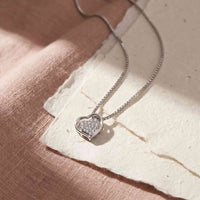 Open Heart vedhæng i 18 karat hvidguld med 0,07 carat diamanter på hvid baggrund