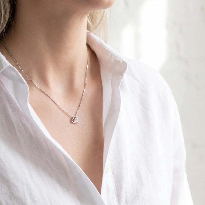 Open Heart vedhæng i 18 karat hvidguld med diamanter båret på en kvinde