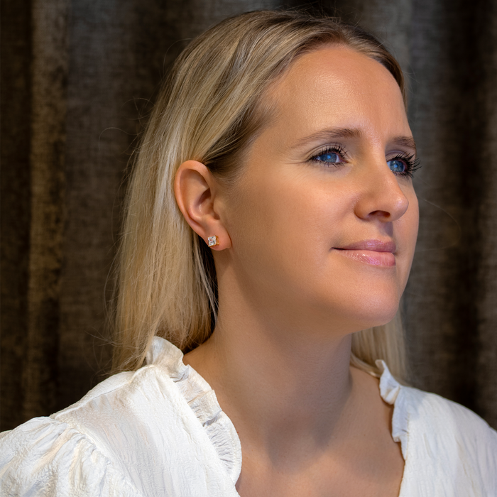Model iført Princess-cut VI solitaire ørestikker i forgyldt sølv