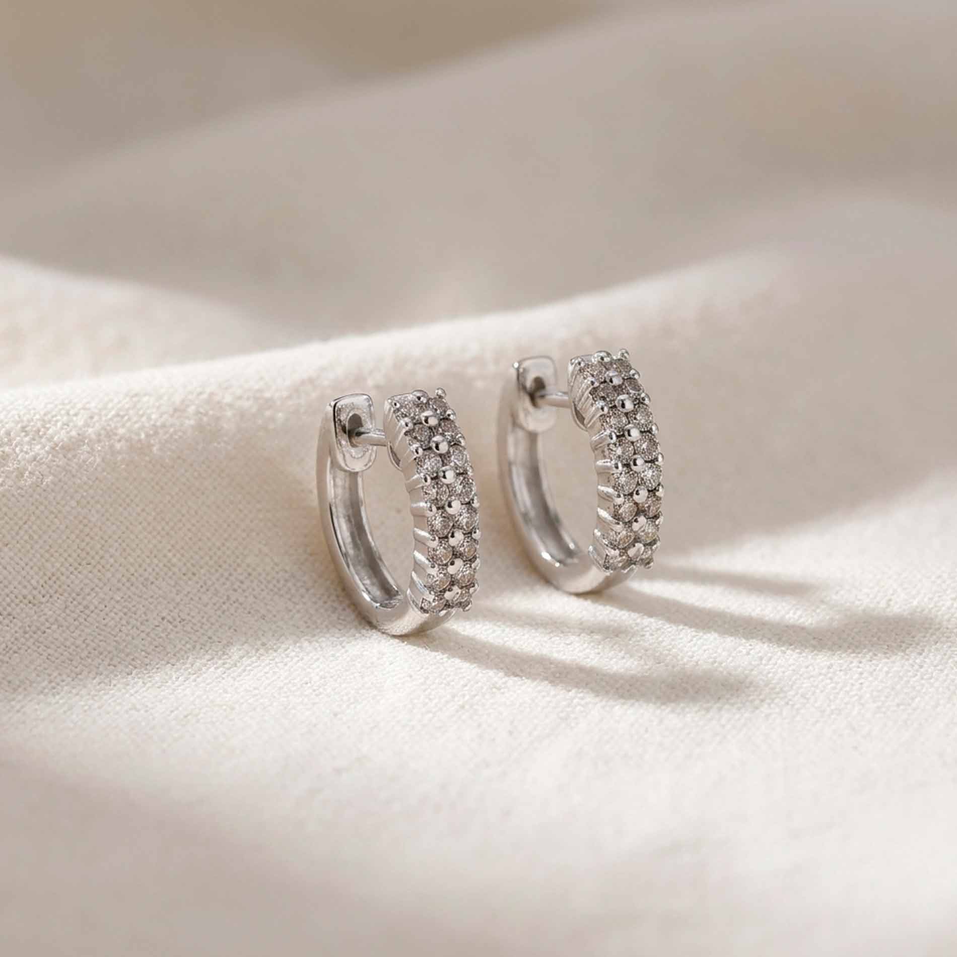 Rose creoler i 18 karat hvidguld med 0,23 ct. hvide diamanter på en lys baggrund