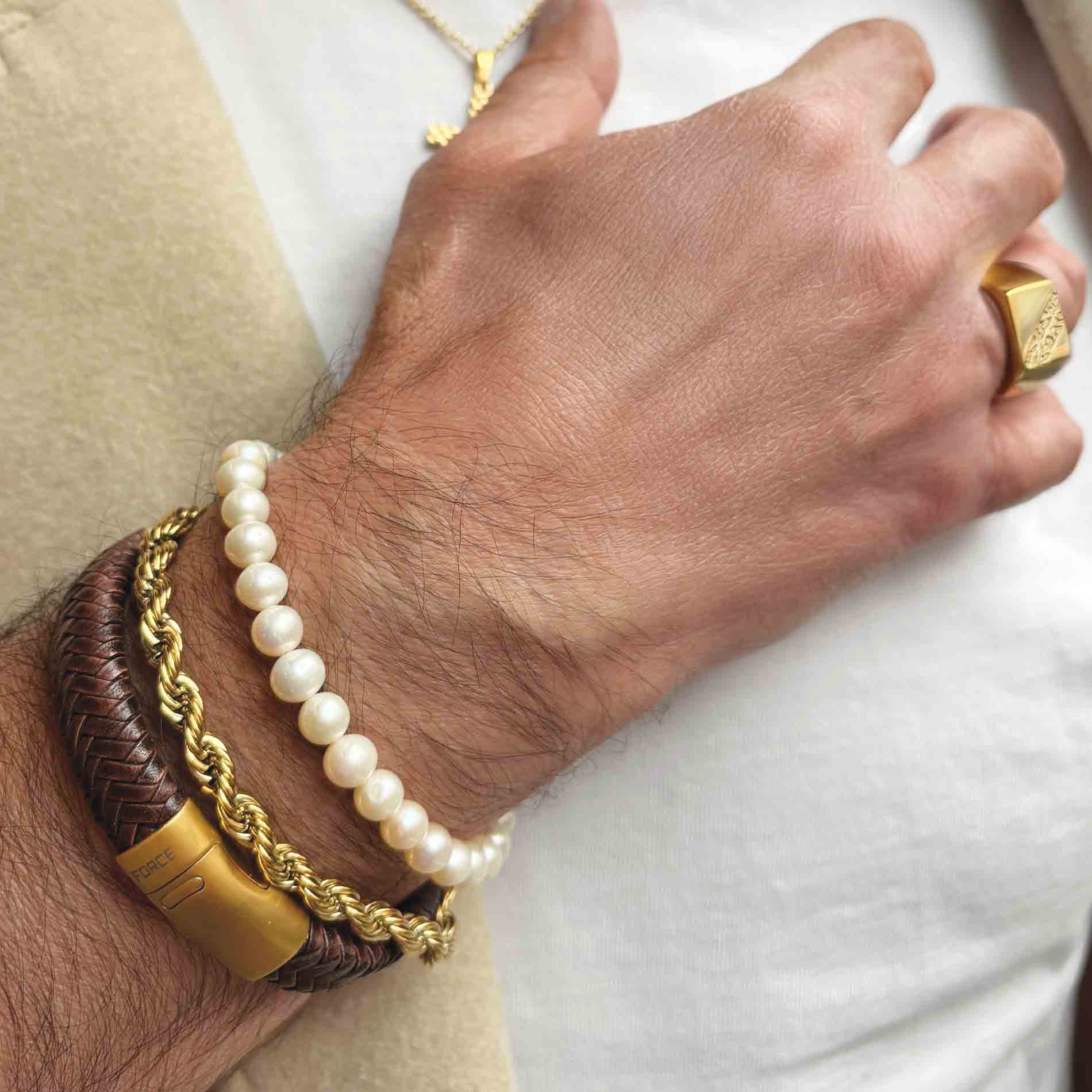 Scrouples armbånd med lyse ferskvandsperler på 6-7 mm vist på håndleddet sammen med andre armbånd.