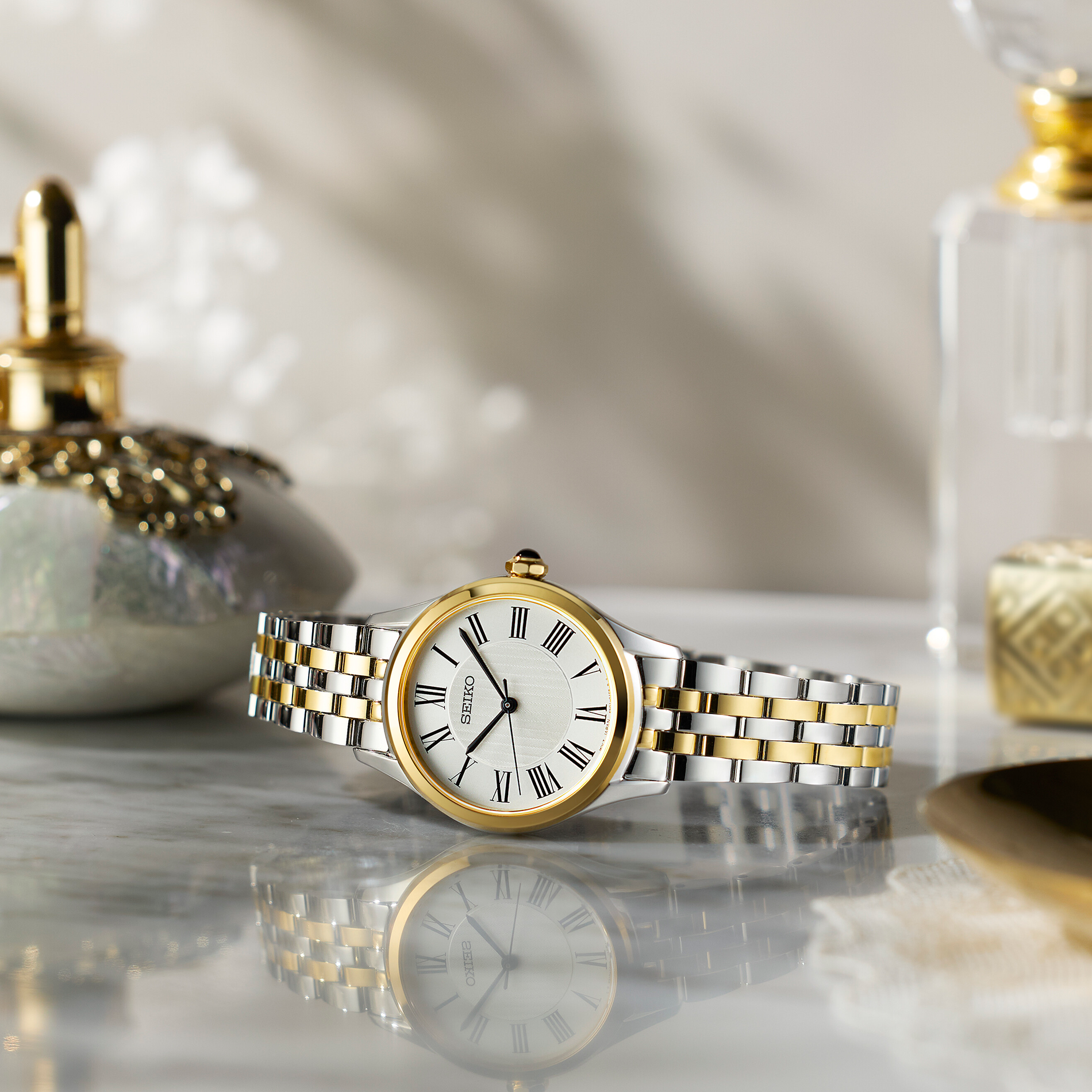 Seiko Classic dameur SUR612P1 i stål med guldfarvet krans, romertal og tofarvet stållænke