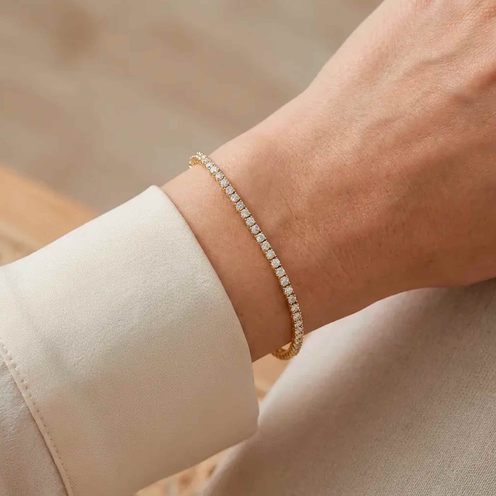 Tennisarmbånd i 18 karat guld med hvide diamanter båret på håndleddet