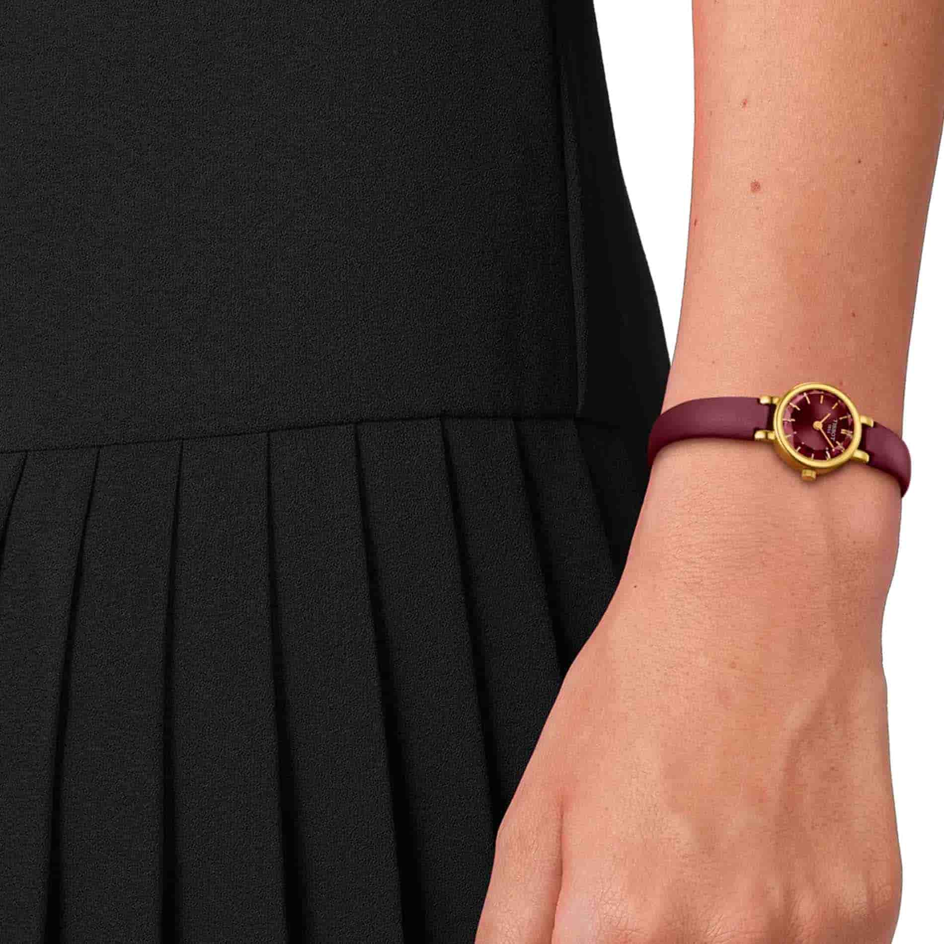 Tissot Lovely Round 19,5 mm dameur med bordeaux urskive og læderrem vist på håndleddet.