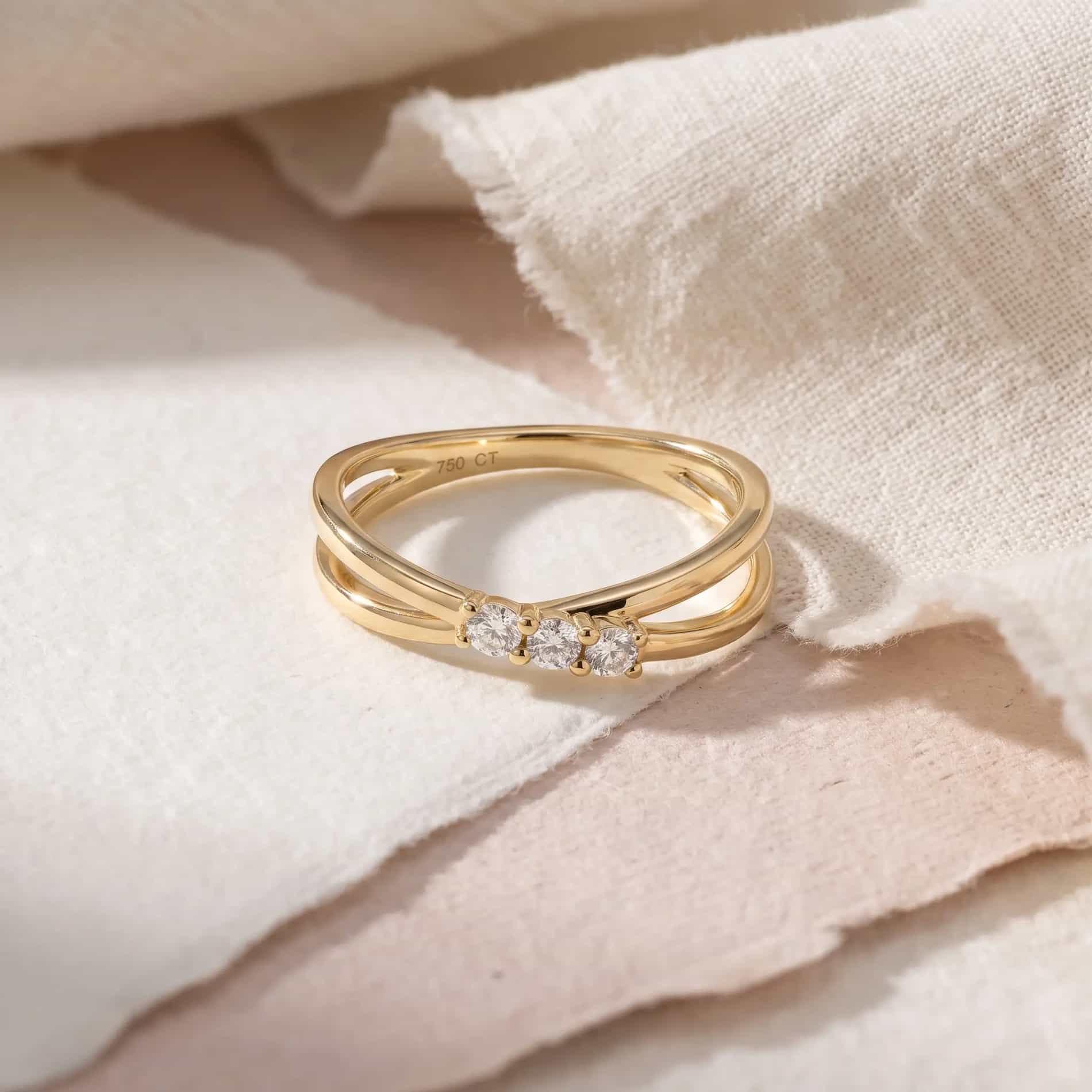 Vigga ring i 18 karat guld med tre hvide diamanter på i alt 0,16 carat, vist på hånd